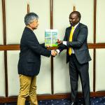 Forest Development Secretary Mr. George Tarus presents key policy documents to Dr. Hiroshi Imae of the Japan International Cooperation Agency (JICA).